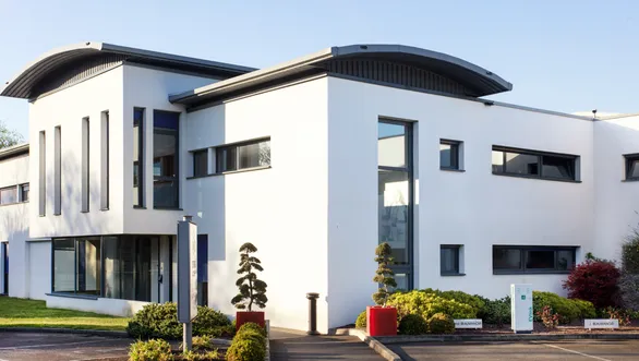 An exterior view of the Beaumanoir Group headquarters, which is a modern white building, with a curved roof